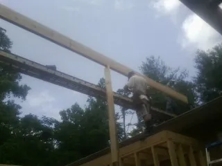 Carpenter setting a ridge beam over a new addition frame — Ice Dam Removal by Roofing Brothers in Gunnison