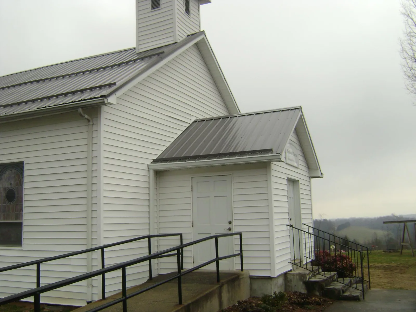 Gray metal roof on a white clapboard church with a steeple in Gunnison
